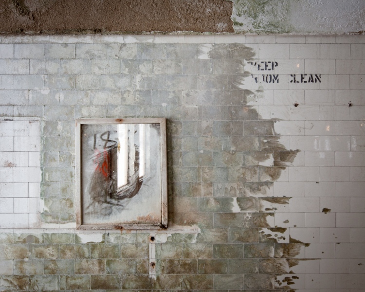 A bathroom mirror and friendly reminder were left behind in the gutted interior.